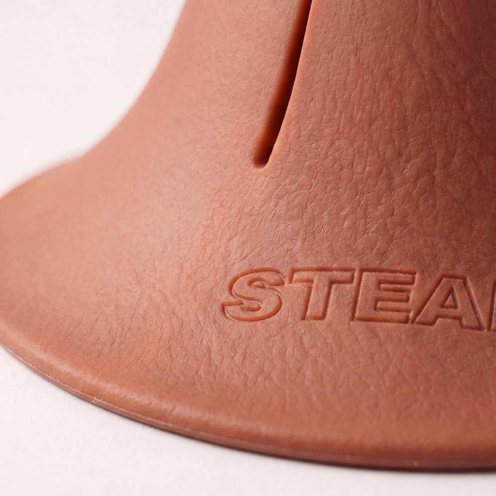 A macro photograph of the flared base of a terracotta Steadi, showing the moulded STEADI mark.